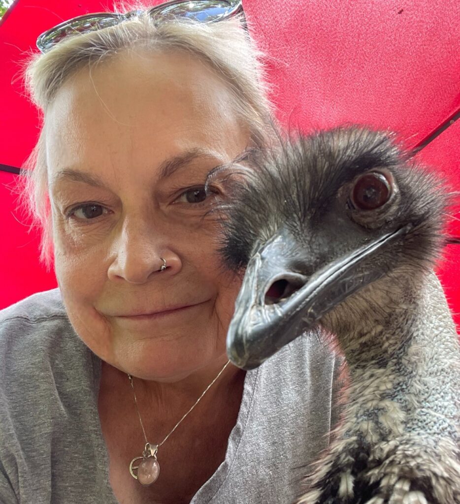 Kymara and her emu, Alice, smiling for a photo.